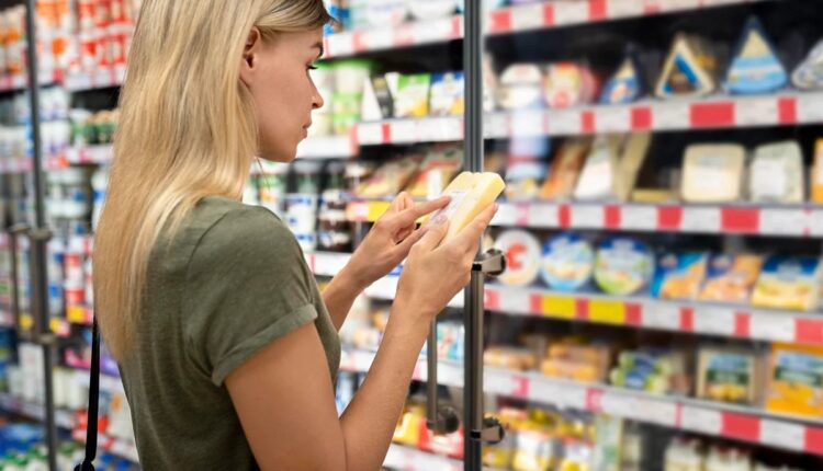 Consumidora lendo o rótulo de um produto no supermercado