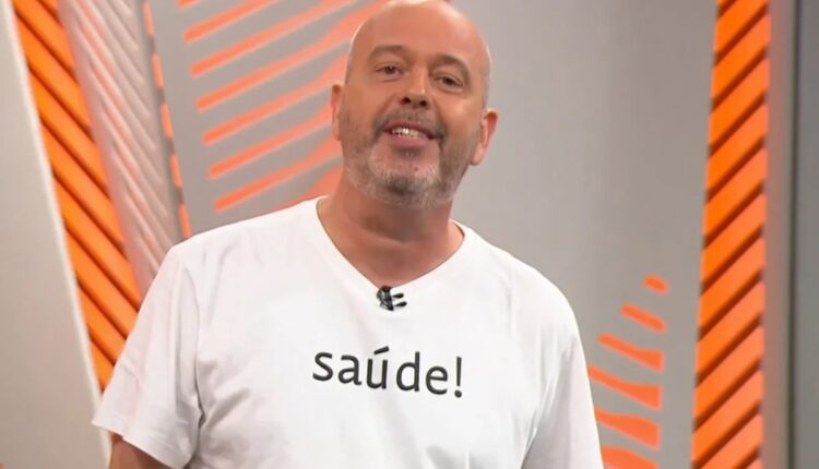 Alex Escobar no estúdio com camisa branca escrita saúde