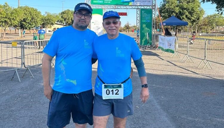 Pai e filho sorrindo juntos em evento de corrida