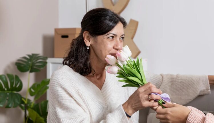 Mulher sentindo o perfume de um buquê de flores
