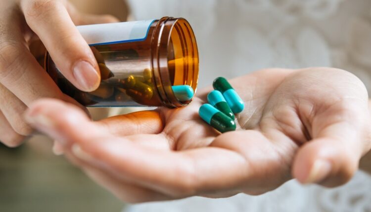 Pessoa segurando cápsulas de medicamento