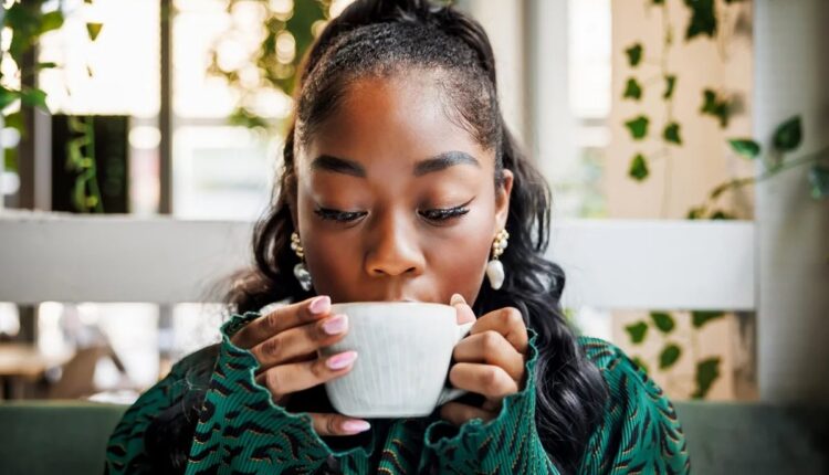 Mulher tomando café em uma cafeteria