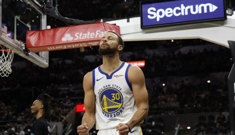 Stephen Curry comemora em quadra com a camisa do Golden State