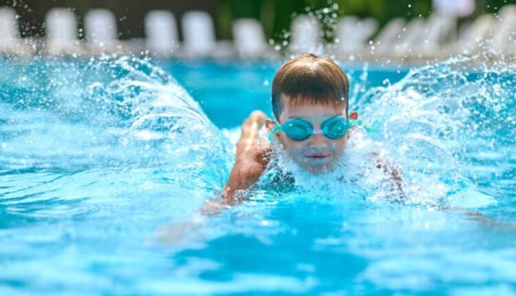 Criança nadando em piscina