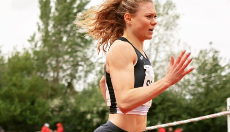 Velocista Beth Dobbin correndo em pista de atletismo