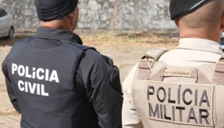 Policiais civis e militares de costas durante operação