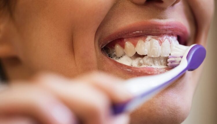 Pessoa escovando os dentes