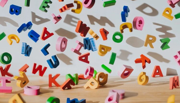 Letras coloridas de brinquedo espalhadas sobre a mesa