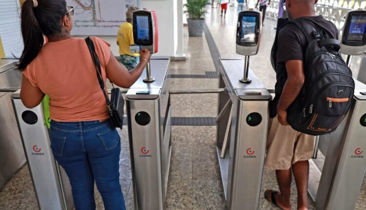 Passageiros passam pelas catracas de terminal de ônibus